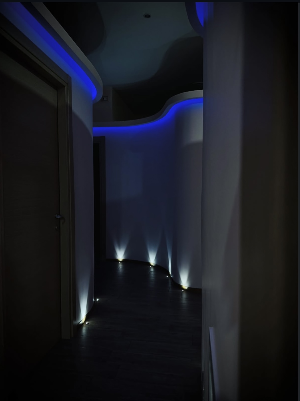 Corridoio con illuminazione LED blu e faretti a terra