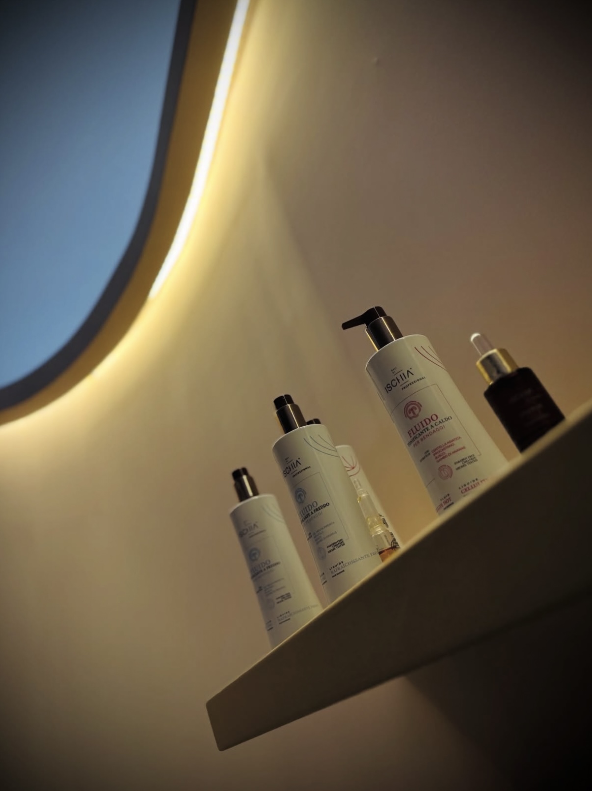 Prodotti Ischia Professional su mensola con specchio tondo illuminato