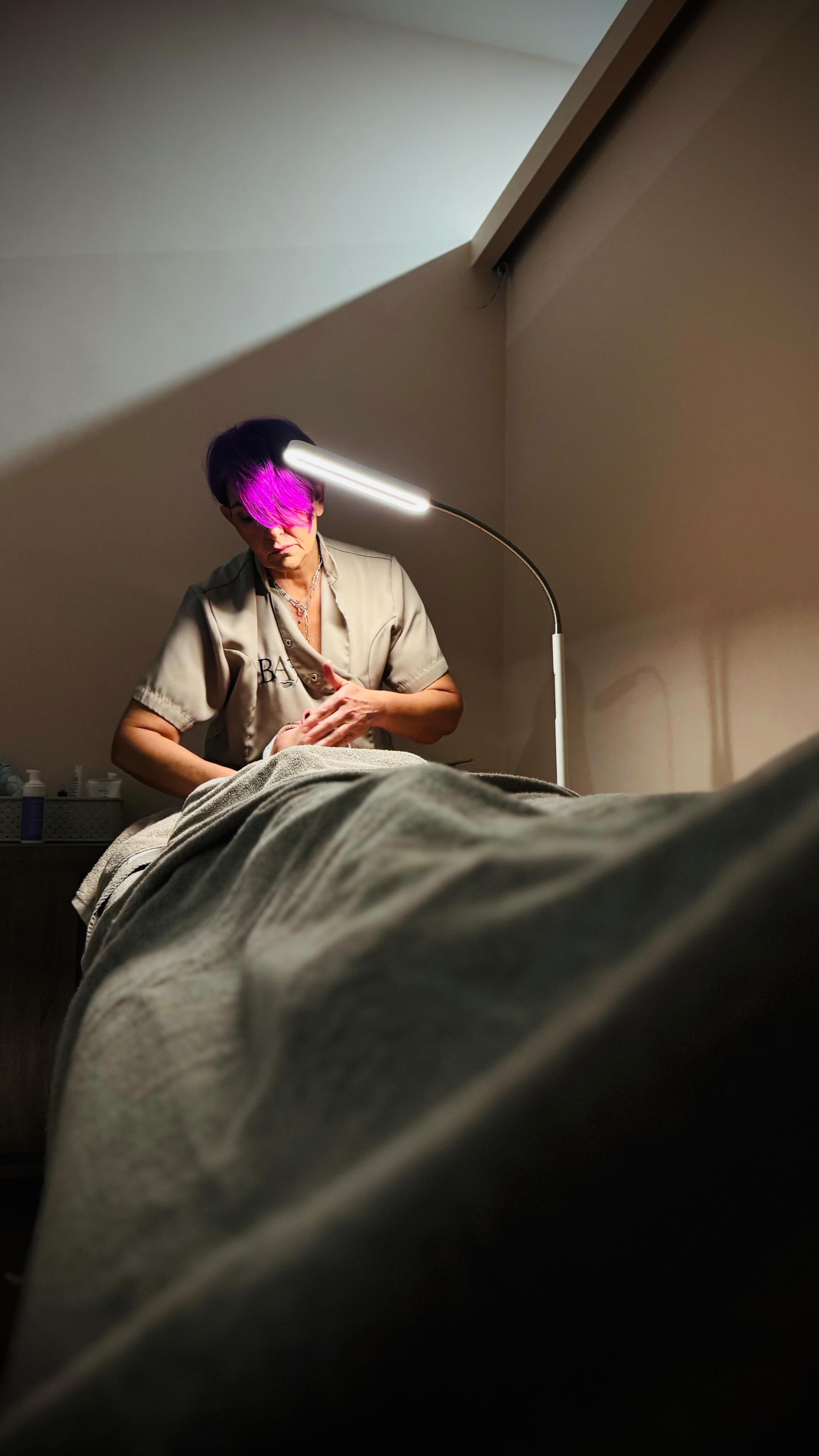 Estetista al lavoro su cliente durante trattamento corpo